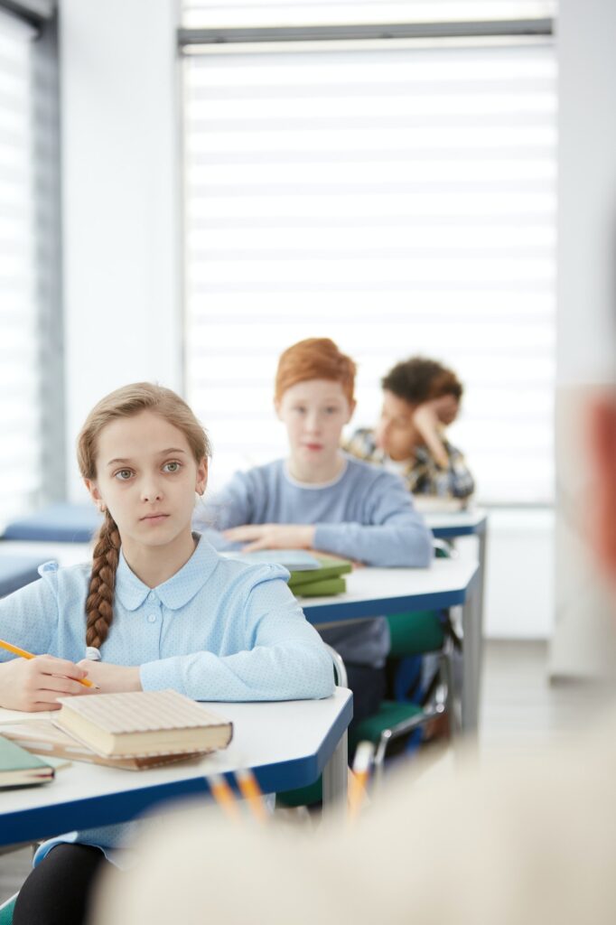 Kids Listening to Teacher in School Classroom